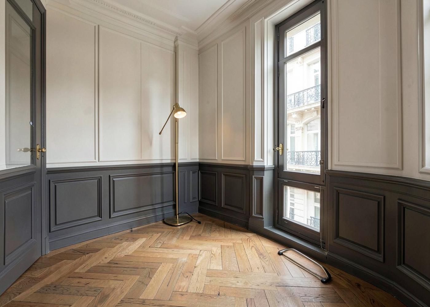 Restored Haussmann salon with charcoal boiserie, herringbone oak parquet and brass floor lamp, Paris interior architecture by Maison Quari Vera